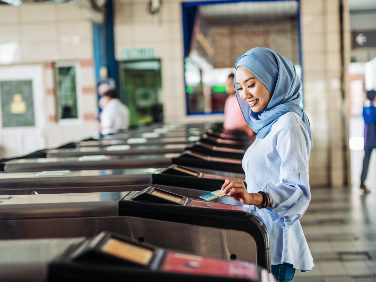 woman tapping a card on the ticket gate