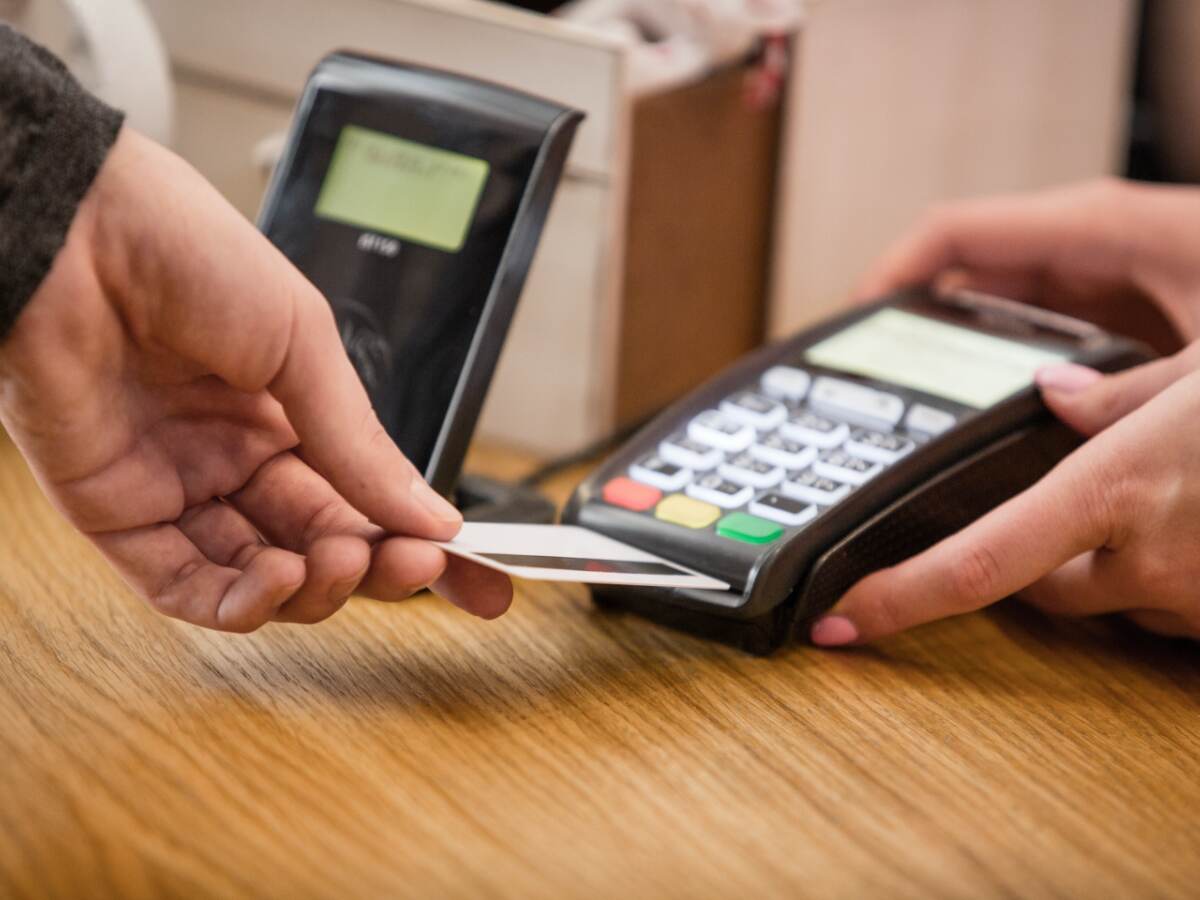 person inserting a credit card into a payment terminal