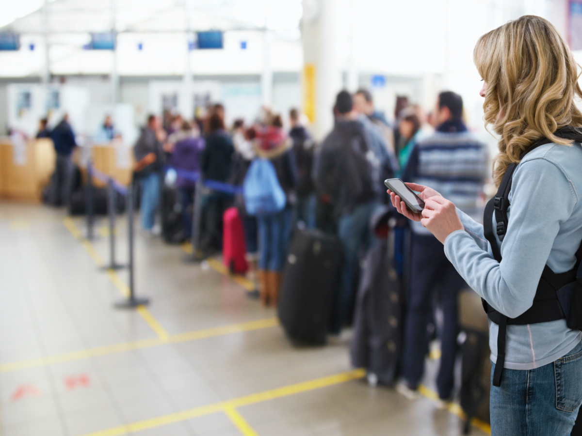 Person using cellphone in line at the airport