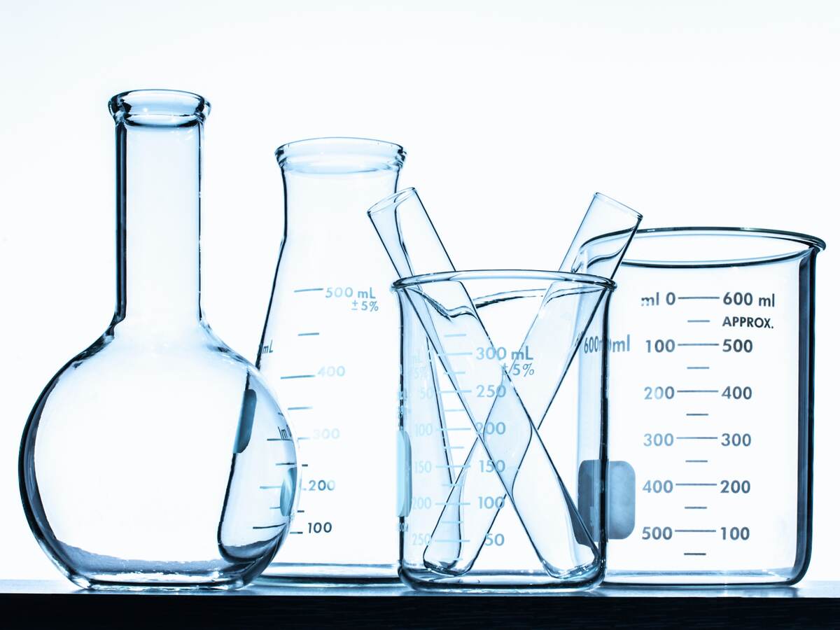 Glass beakers in front of a white wall