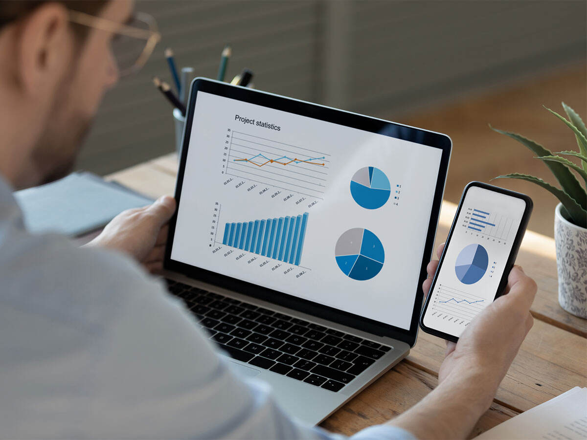 Person viewing graphs on a mobile device and on a laptop