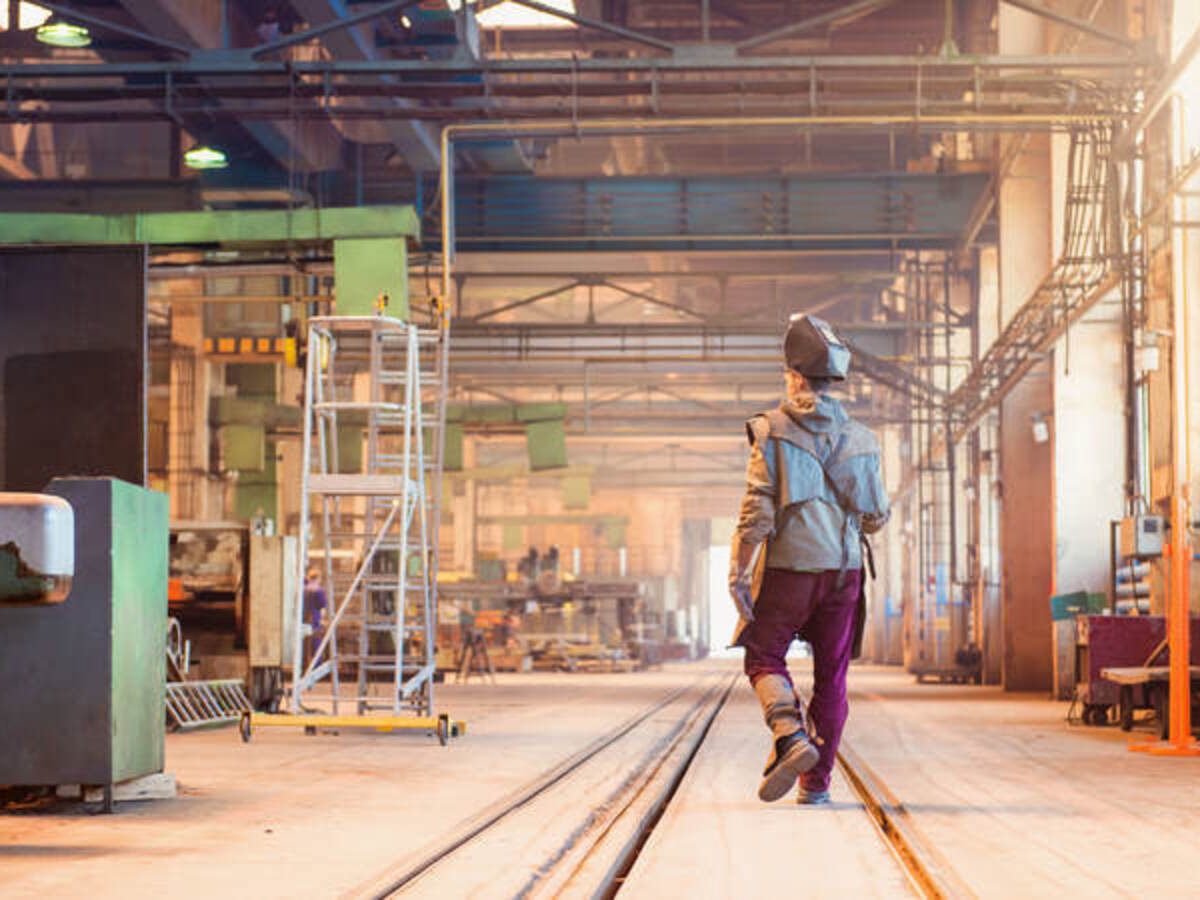 Welder walking down a warehouse