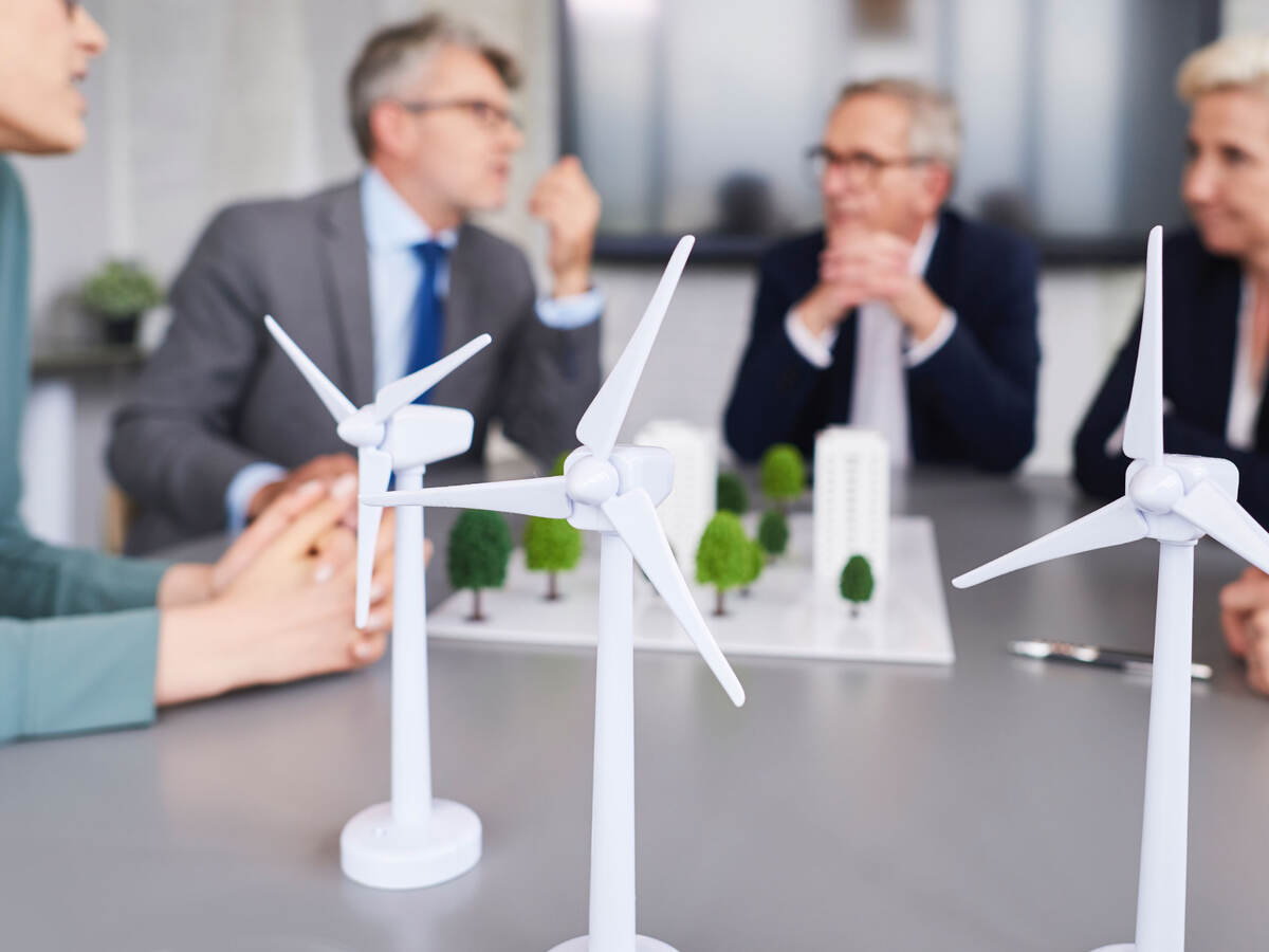 Scale models of wind turbines on a desk during a planning meeting