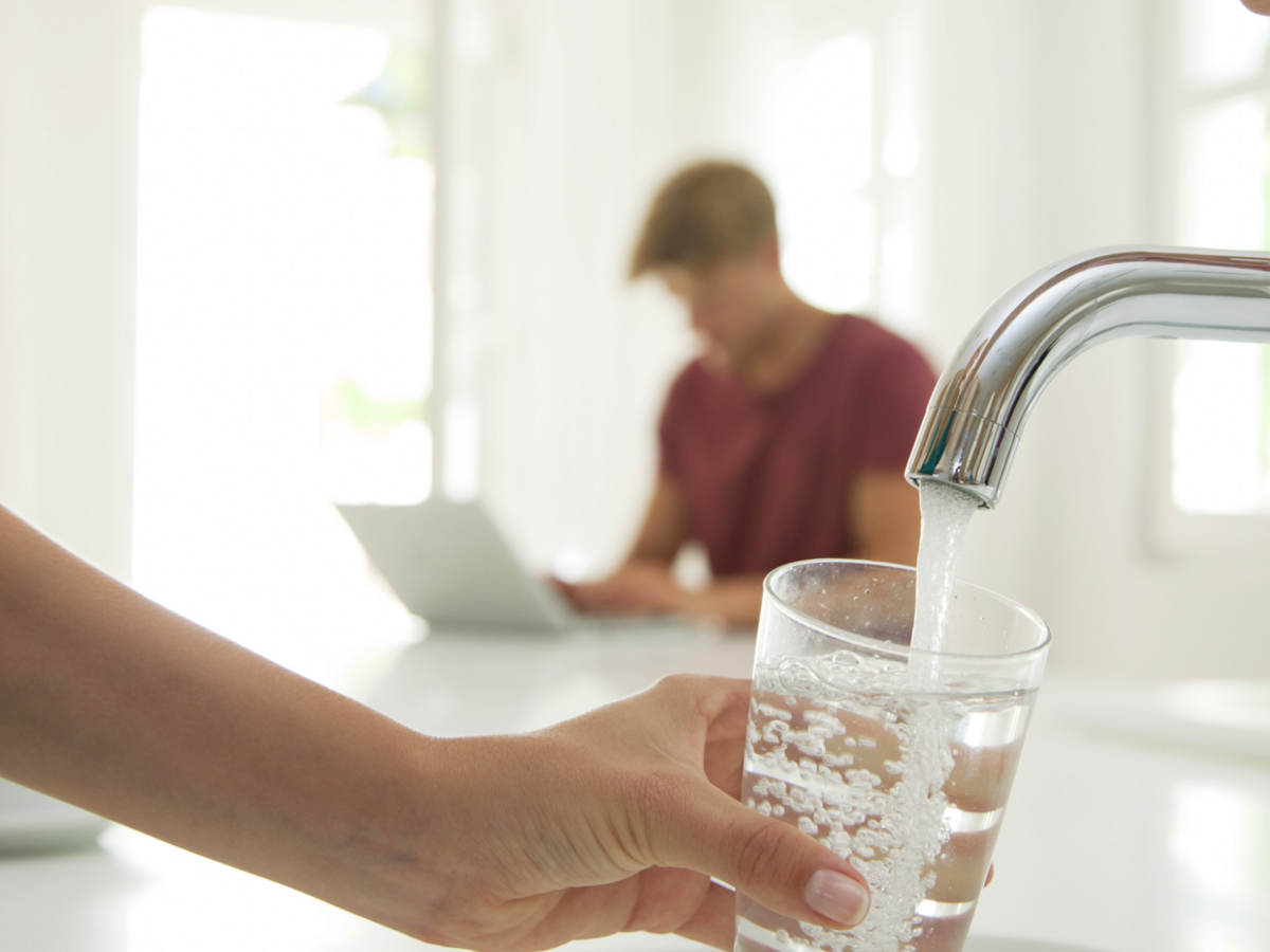 Person filling a glass with water