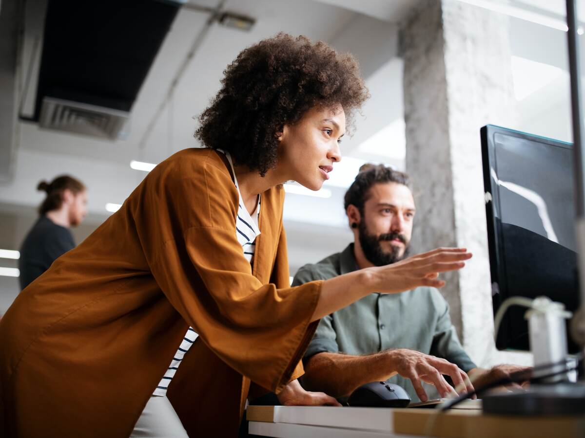 A man and a woman looking at a computer