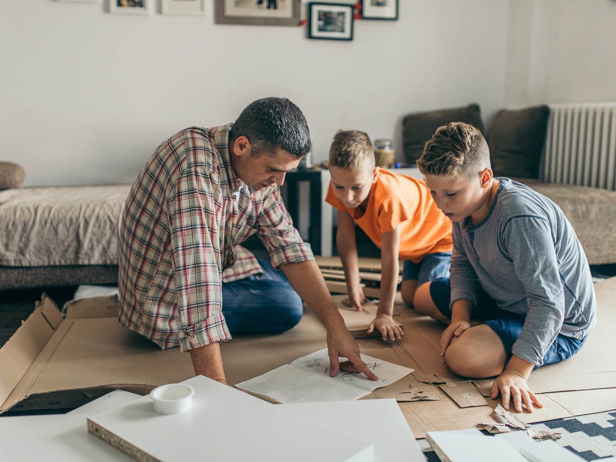 Father assembling furniture with his kids