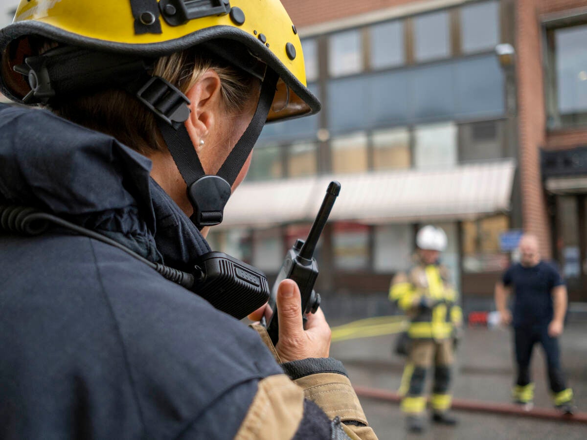 Firefighter with a radio device outside of a building