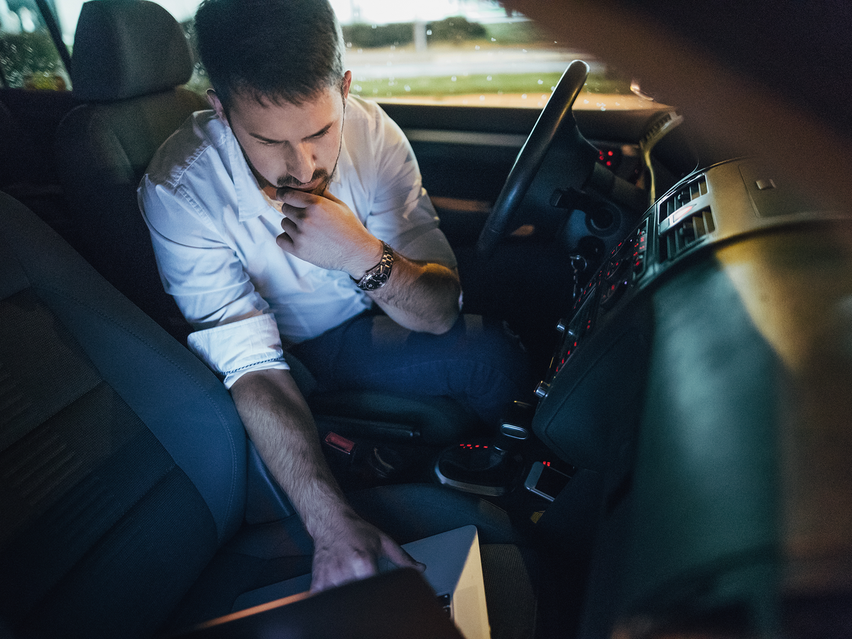 Person working on laptop inside car