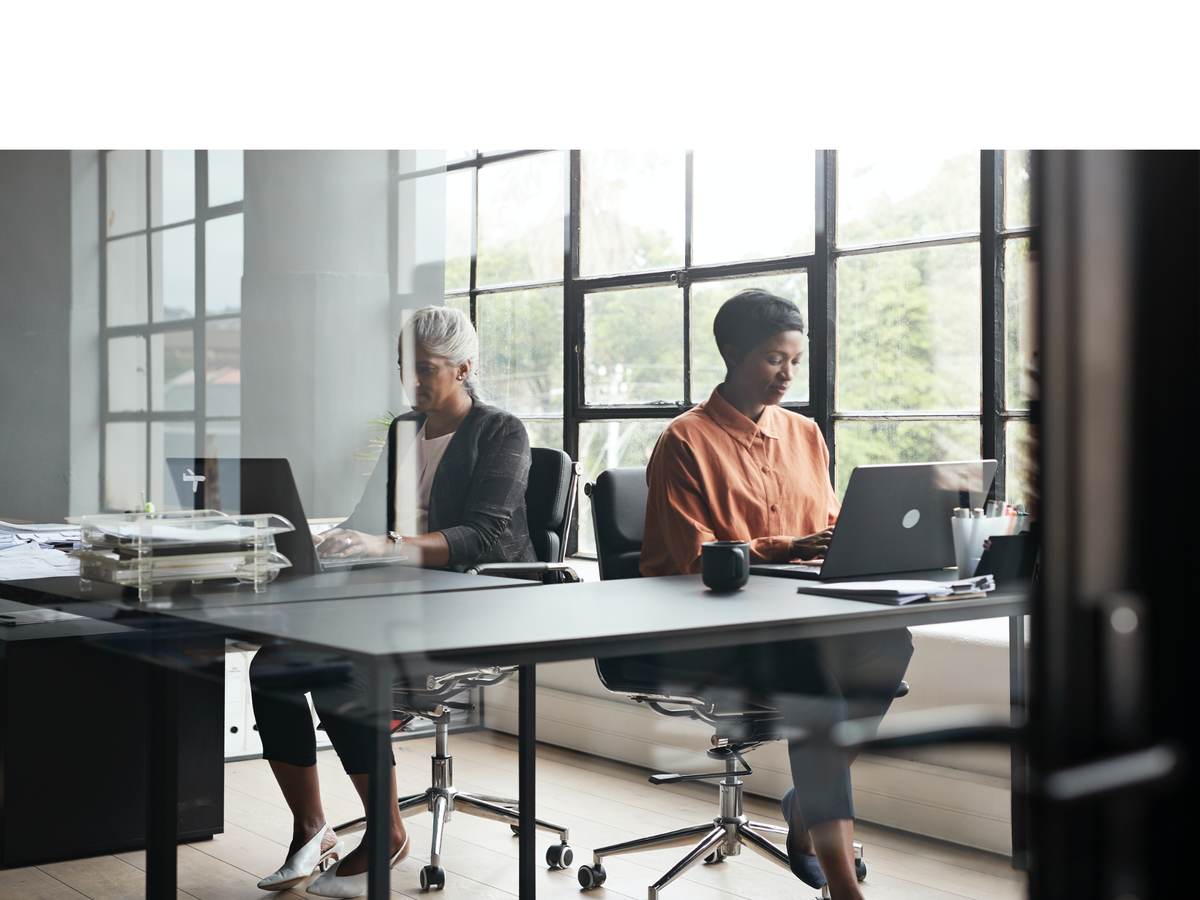 Two people working sided by side on laptops