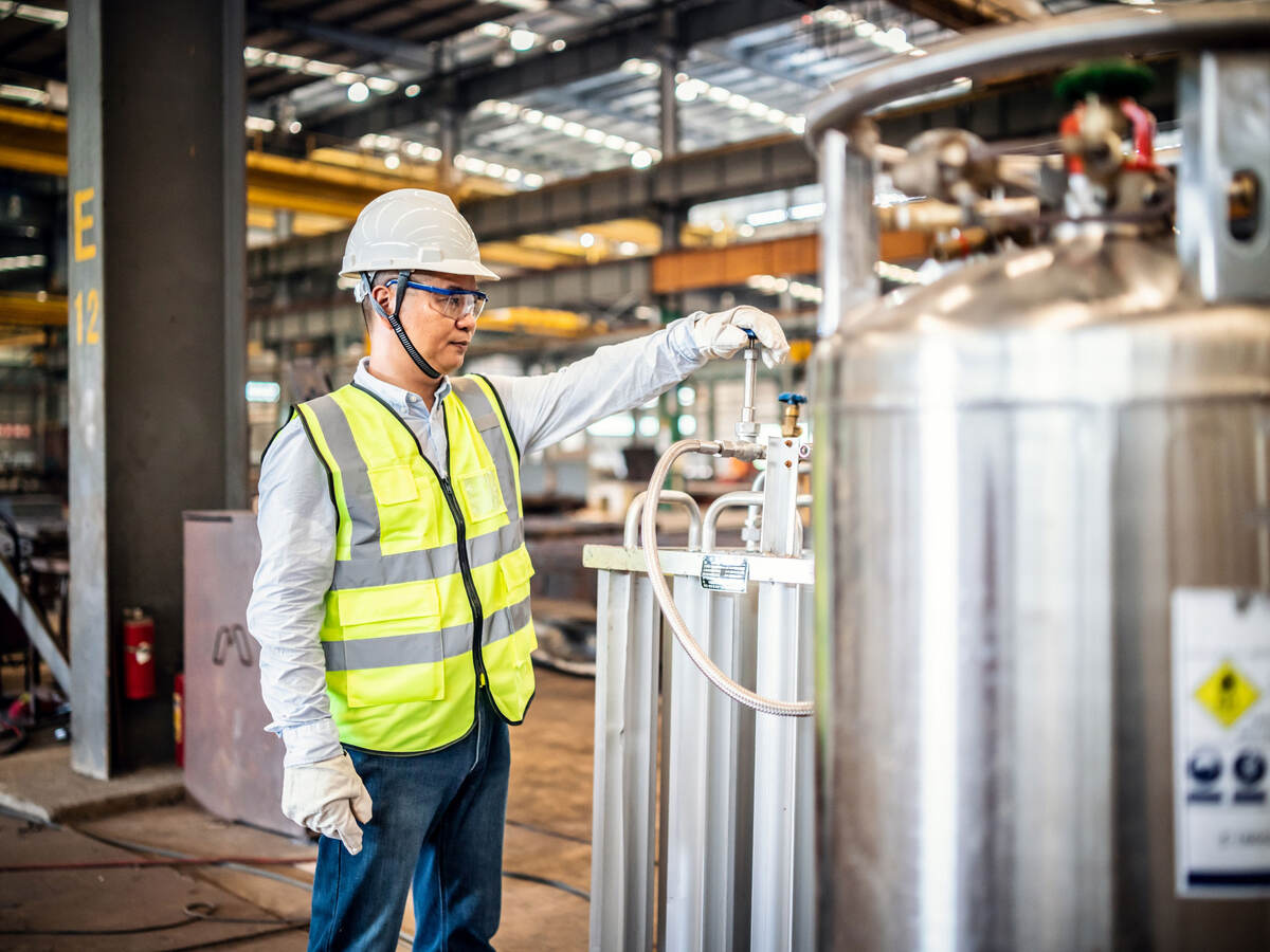 Worker operating a gas tank in a factory