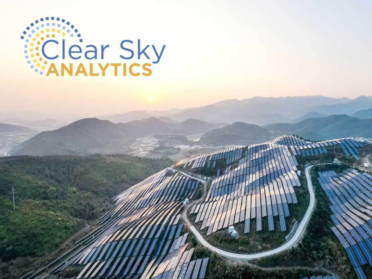 Aerial view of a solar farm along a lush hillside