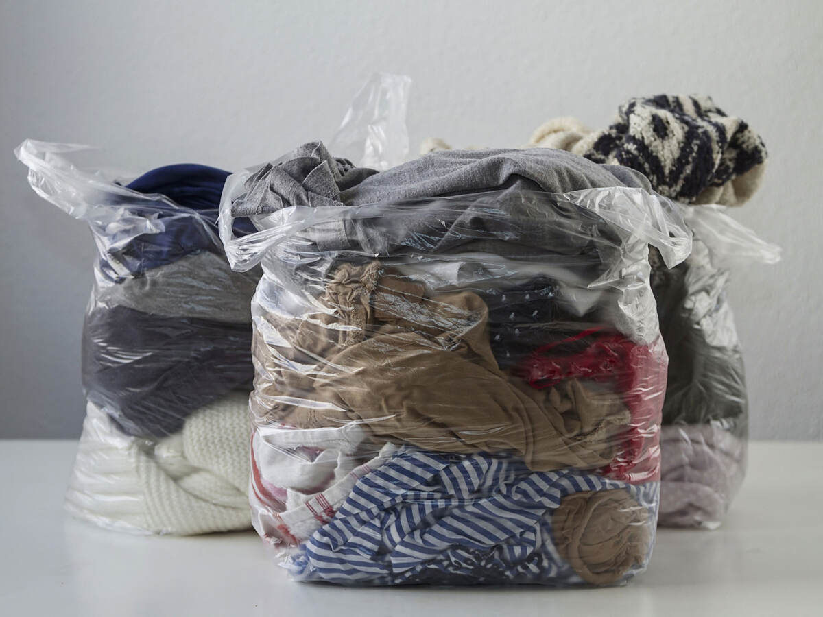 Clothes in plastic bags conveying promotion of recycling clothing, give it second life than become waste