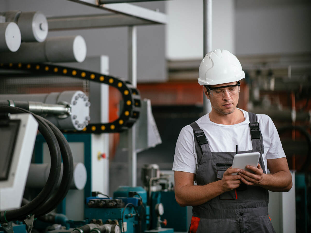 Worker in hardhat working with a tablet