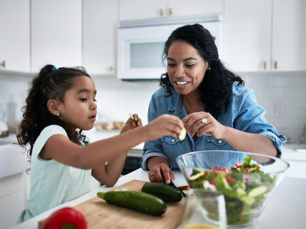mother and daughter making a salad in a kitchen