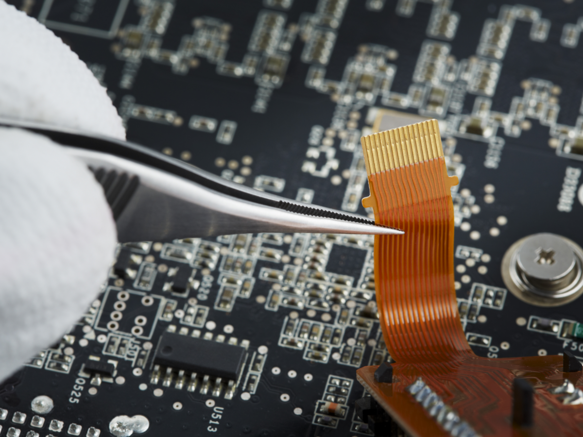 Close up of human hand repairing printed circuit board