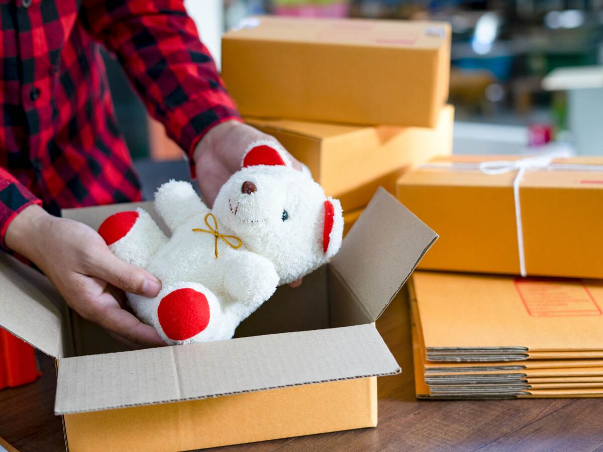 Retailer placing a toy in a box to ship