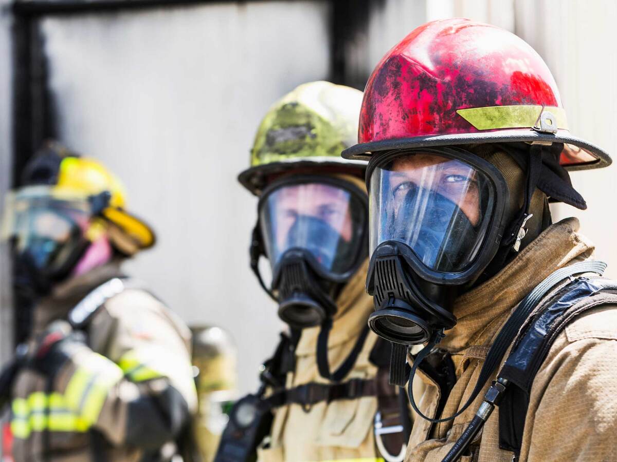 Three firefighters wearing protective equipment