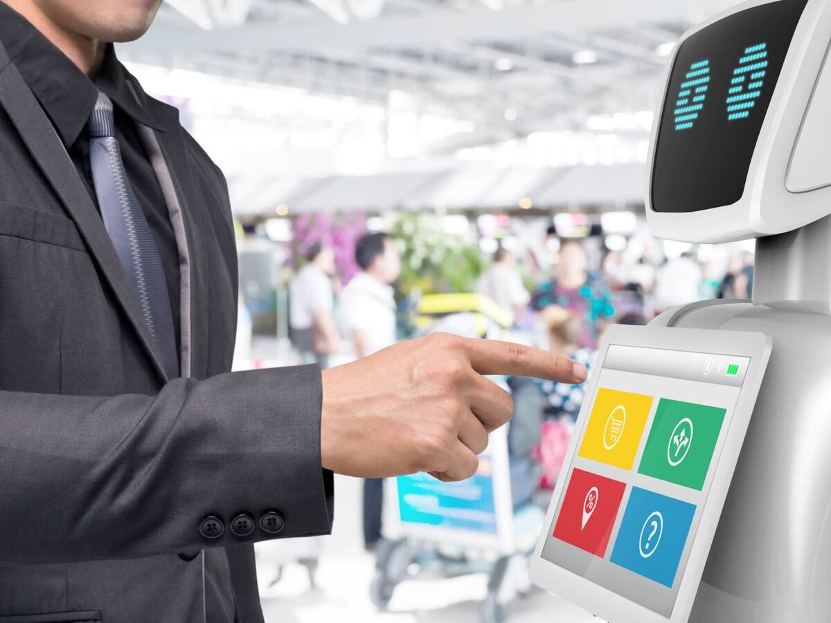 Businessman using autonomous personal assistant robot for navigation at the airport