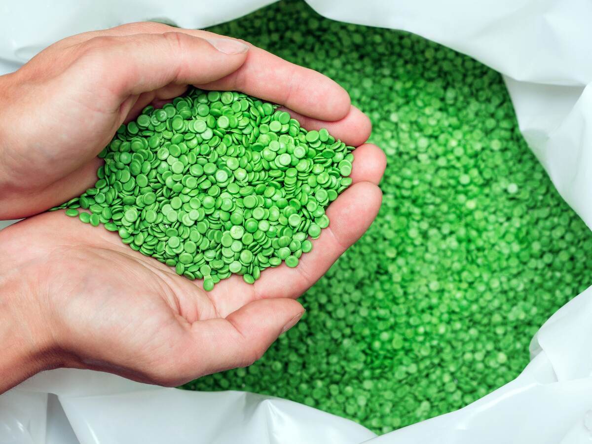 Hands holding biodegradable plastic pellets
