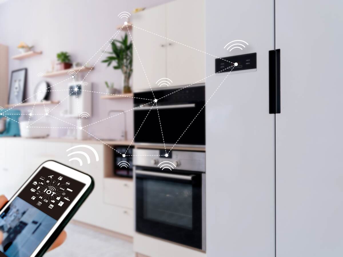 View of smart home from kitchen with appliances being operated by a mobile device.