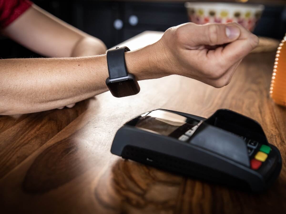 Close-up of man using smart watch to pay in a restaurant. 