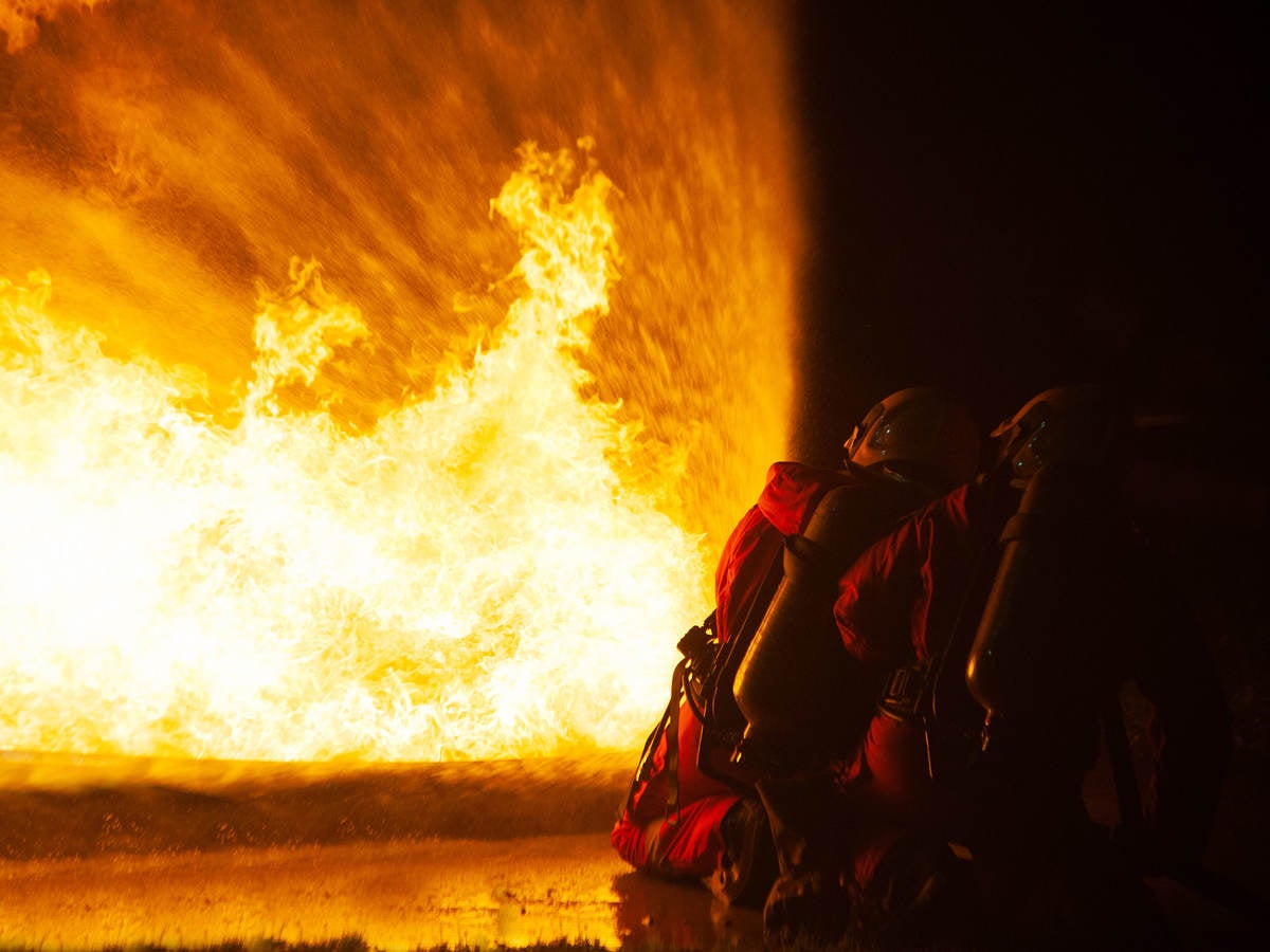 Firefighters spraying water and foam to put out a brutal fire on the floor.
