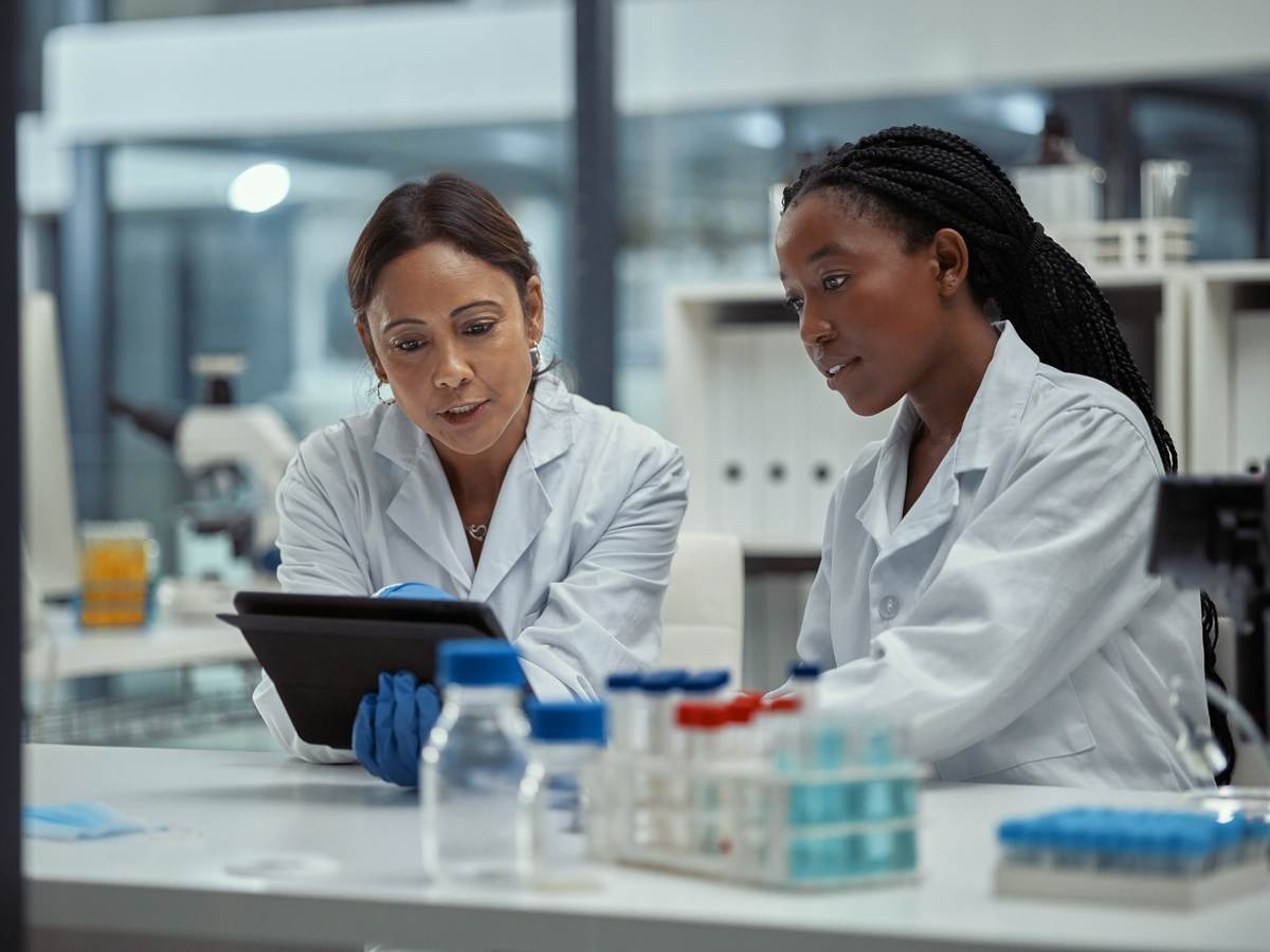 Shot of two scientists working together on a digital tablet in a lab.