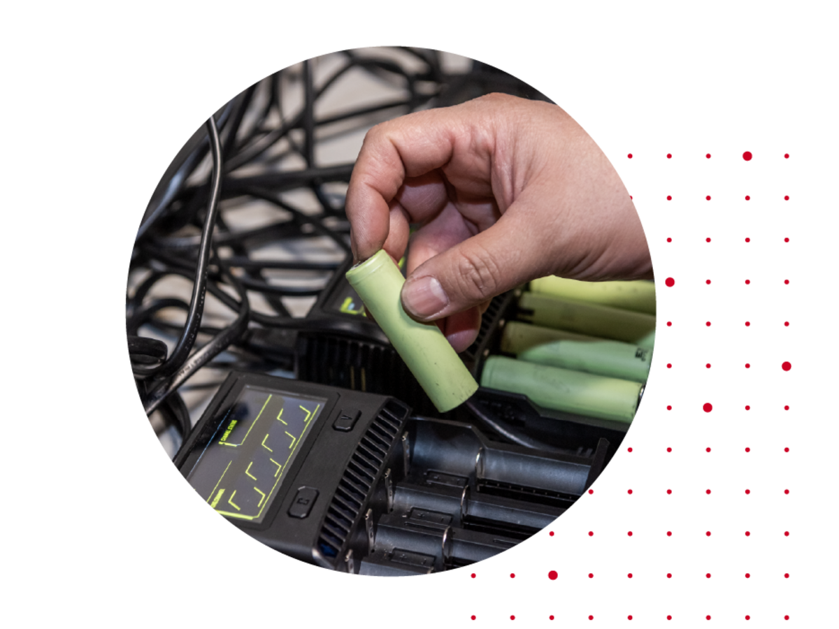 Person inserting green batteries into a device