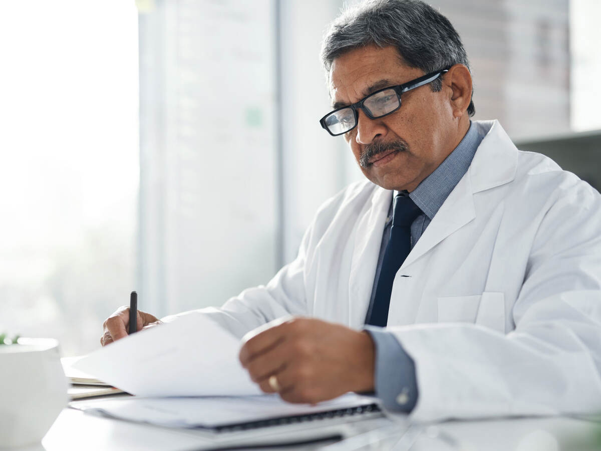 Doctor sitting at a desk doing paperwork