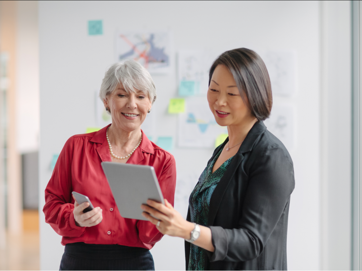 Two women holding mobile devices looking at screens