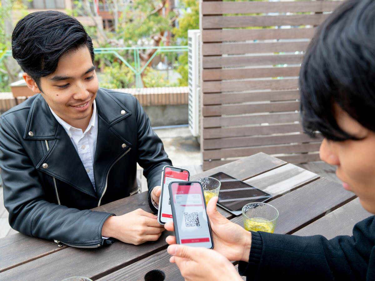 Two people demonstrating mobile to mobile payment transfer