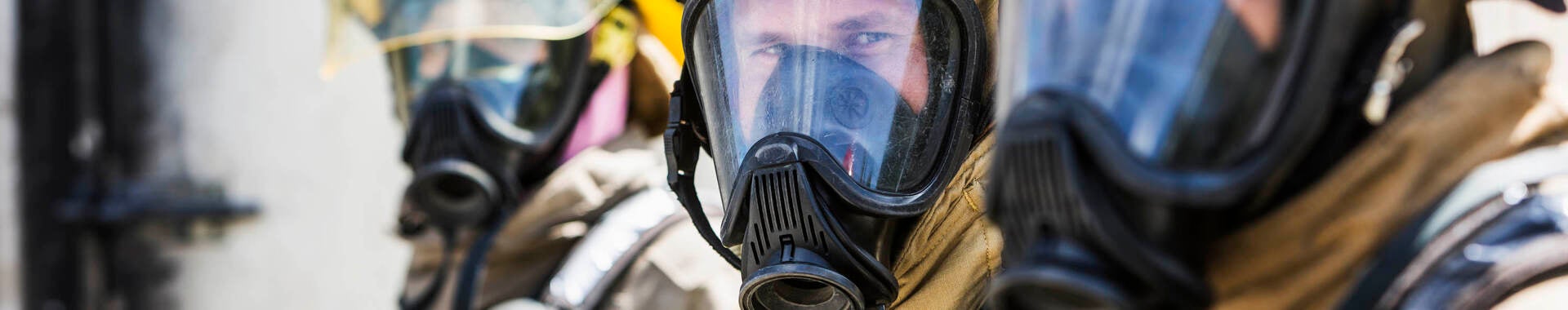 Three firefighters wearing oxygen masks