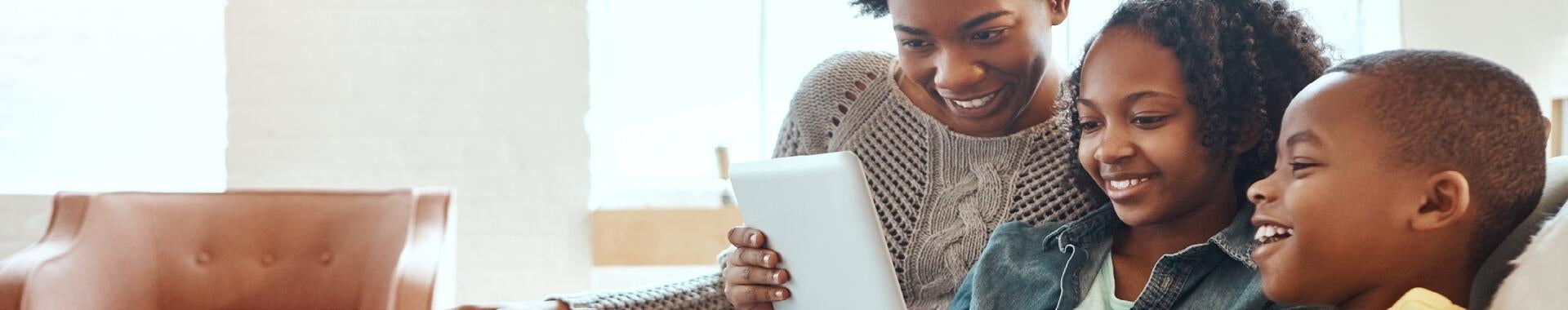 Family on couch looking at tablet