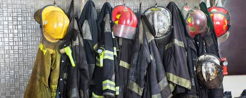 Firefighter gear hangs in a row, waiting for the next call