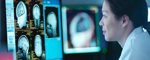 Scientist looking at 3D rendered graphic scans from Magnetic Resonance Imaging (MRI) scanner, close up