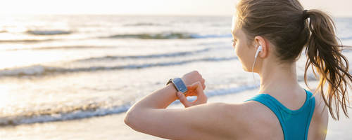 woman working out, looking at smartwatch