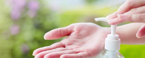 Female hand dispensing hand sanitizer onto open palm