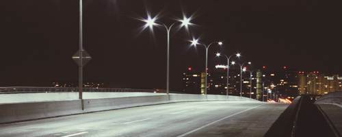 Streetlights at night on quiet road. 
