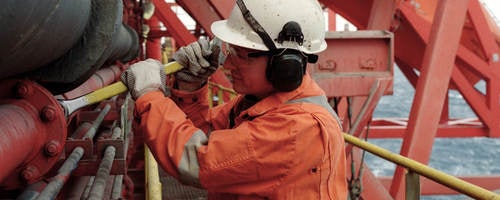Working in a hard hat working in a petroleum refinery