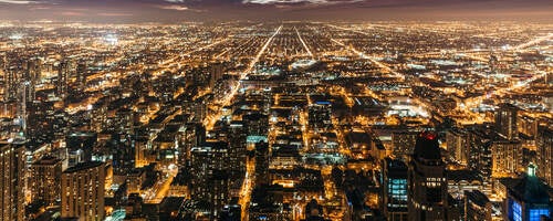 Cityscape at night with many lights from homes, businesses, roads