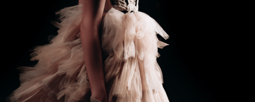 Runway fashion show with a woman in a lush beige dress