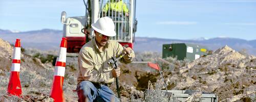 Worker installing cables for underground distribution.