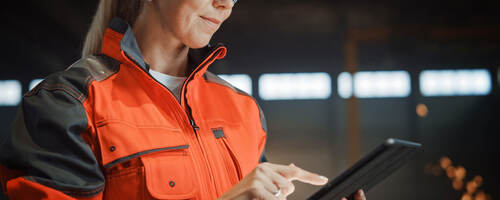 Engineer in PPE working on a tablet