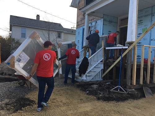 UL employees carry new windows into the Habitat for Humanity house