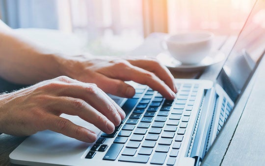 photo of a person's hands on a laptop 