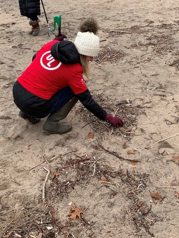 UL volunteer sifts through sand at Lake Michigan beach