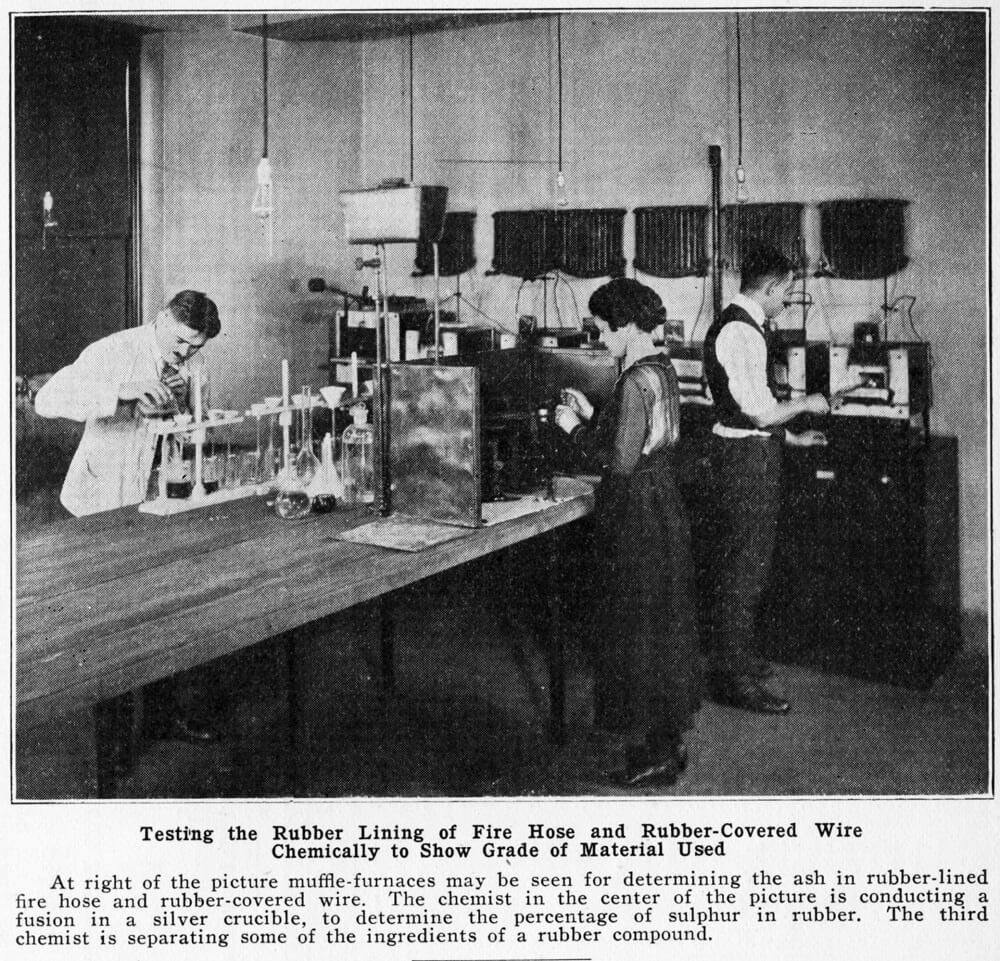 The photo that inspired Rachel Madden to research the chemist in the middle. Louise Logie appears to be pouring a substance from her right hand into a crucible in her left hand. She is wearing a long dark skirt with a stylish sheer blouse, and shiny patent leather shoes peek out at the bottom of the photo.
