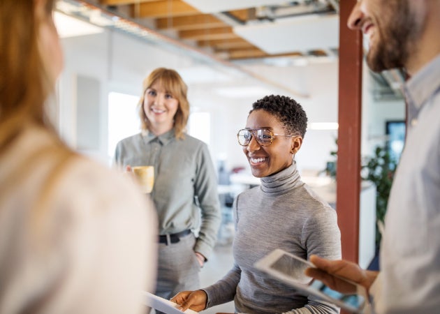 A diverse group of four young professionals talking in the office