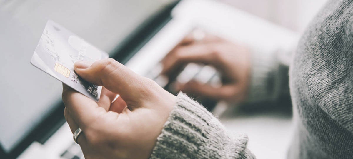 Typing in credit card details on a laptop
